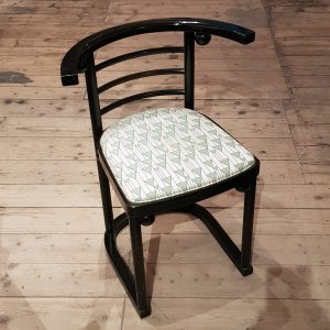 This chair was designed for the theatre cabaret 'Fledermaus' (the ‘Bat’) in Vienna in 1907 by architect designer Josef Hoffmann. It was designed by the Wiener Werkstätte, exclusive Viennese workshops co-founded by Hoffmann in 1903. Inspired by the Guild of Handicraft the English architect and designer C.R. Ashbee had set up in London, the workshops wanted to create good, simple design and new modern forms. However, the design was popular and remained in production at Jacob & Josef Kohn until at least 1916. The chair was also produced by Thonet: it featured oval-shaped pieces at the joints, in contrast to the round spheres of the J. & J. Kohn version. These chairs are from a set re-issued in the 1980's by Thonet and have been restored and re-covered in a fabric produced in Austria with an original Secessionist pattern from their archive.