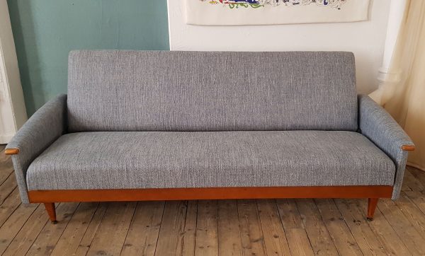 A Mid Century sofa bed completely restored with new foam and covered in an Italian linen in shades of blue and grey. Folds flat to become a bed.