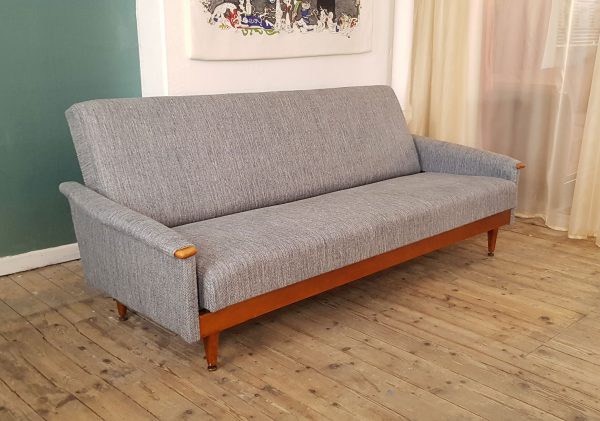 A Mid Century sofa bed completely restored with new foam and covered in an Italian linen in shades of blue and grey. Folds flat to become a bed.