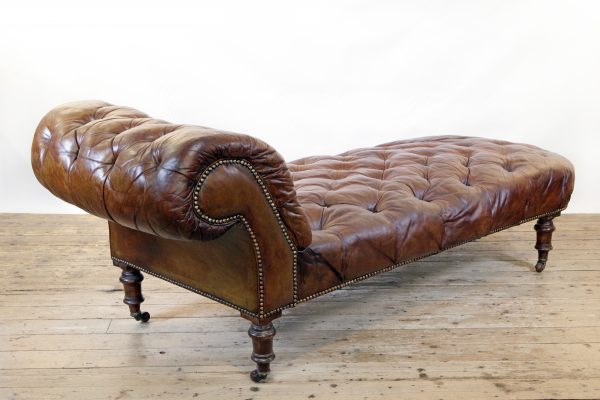 A Victorian buttoned brown leather chaise longue, by Cornelius V Smith