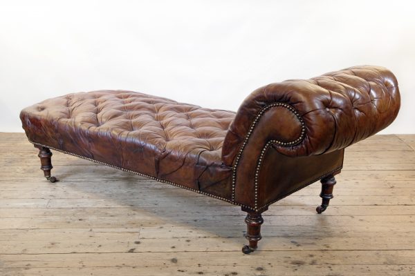 A Victorian buttoned brown leather chaise longue, by Cornelius V Smith