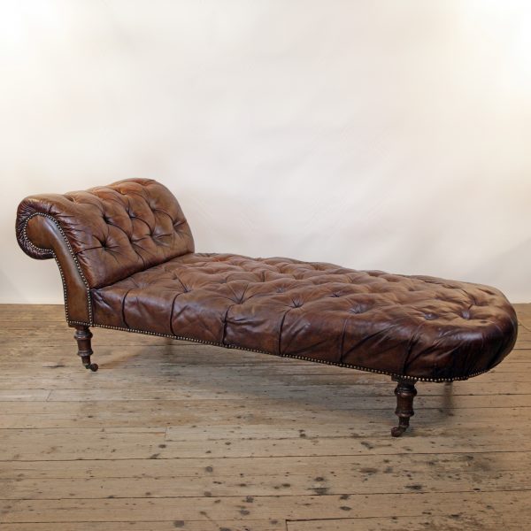 A Victorian buttoned brown leather chaise longue, by Cornelius V Smith