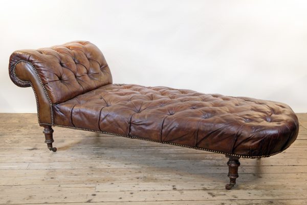 A Victorian buttoned brown leather chaise longue, by Cornelius V Smith